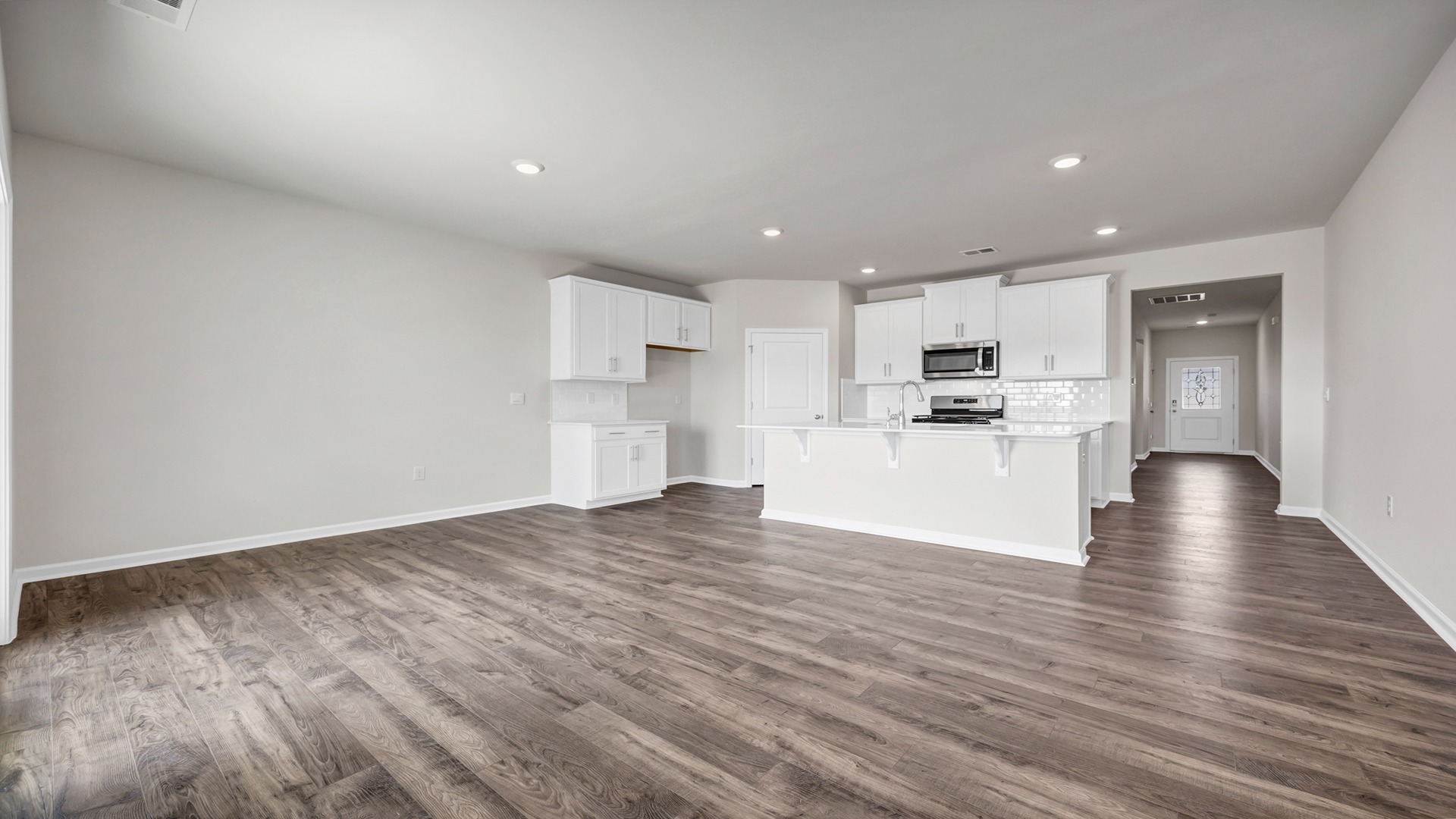 Open concept main living areas and kitchen with RevWood flooring