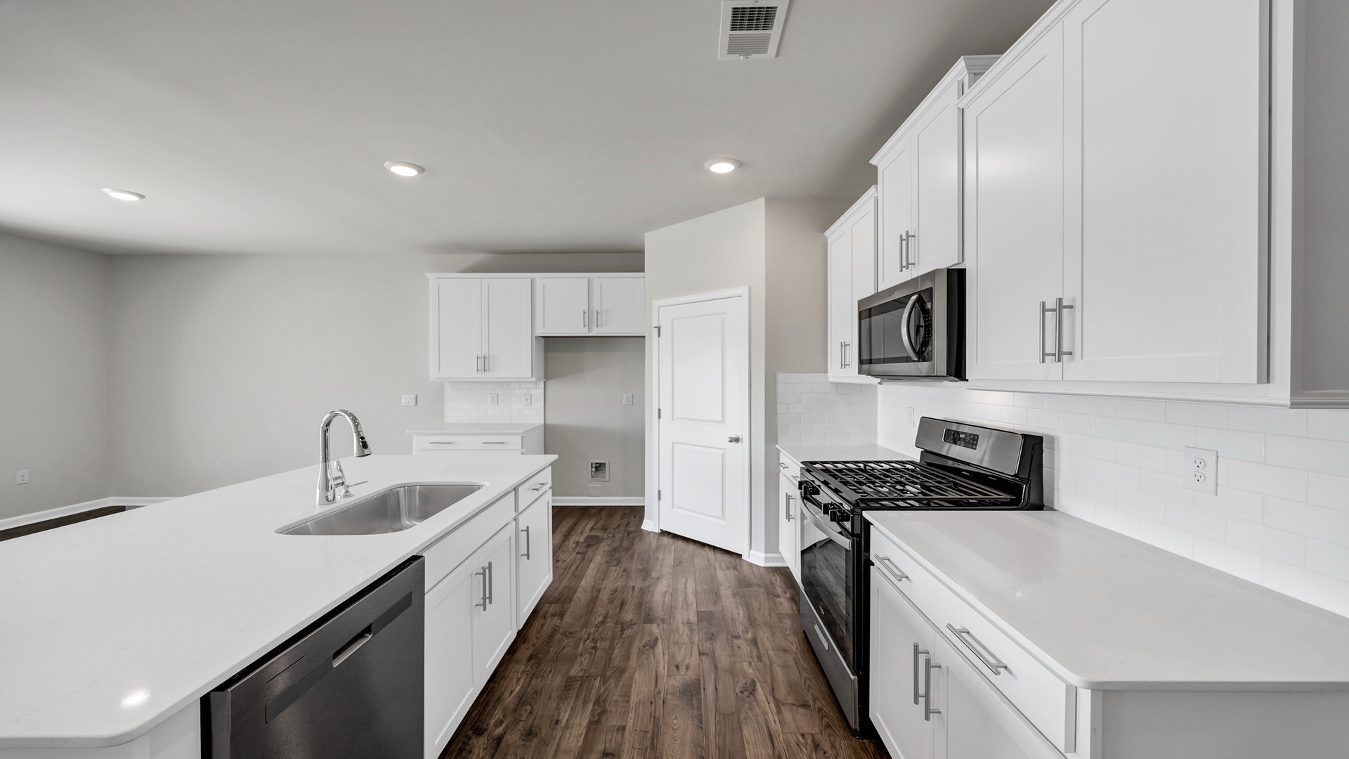 New construction kitchen with white cabinetry and tile backsplash