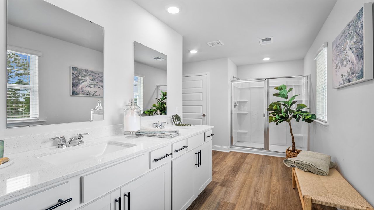 Primary bathroom with double vanity and standup shower