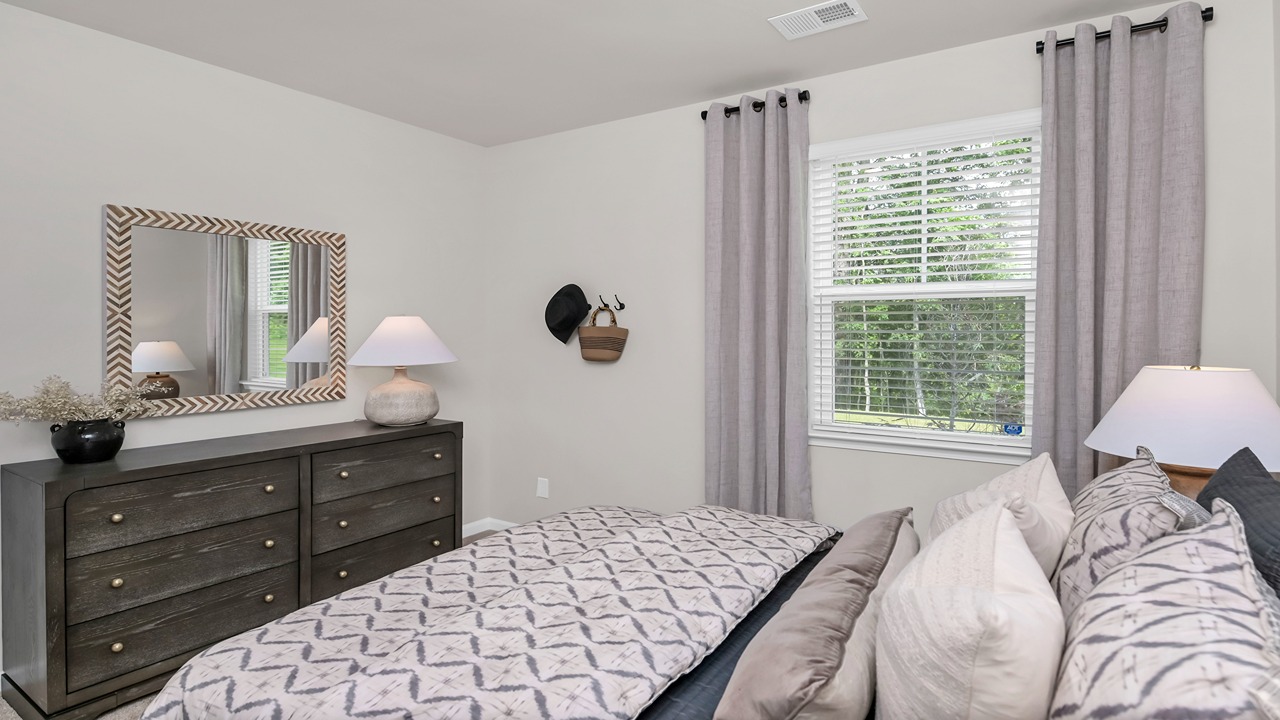Downstairs bedroom with a window and carpet flooring