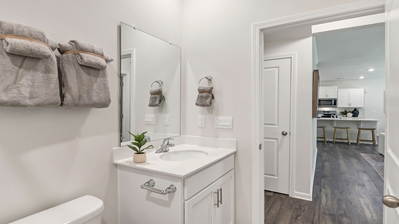 Downstairs full bathroom with white cabinetry