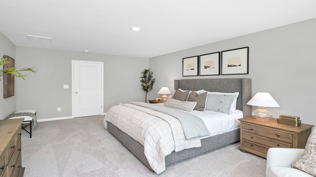 Spacious primary bedroom with carpet flooring