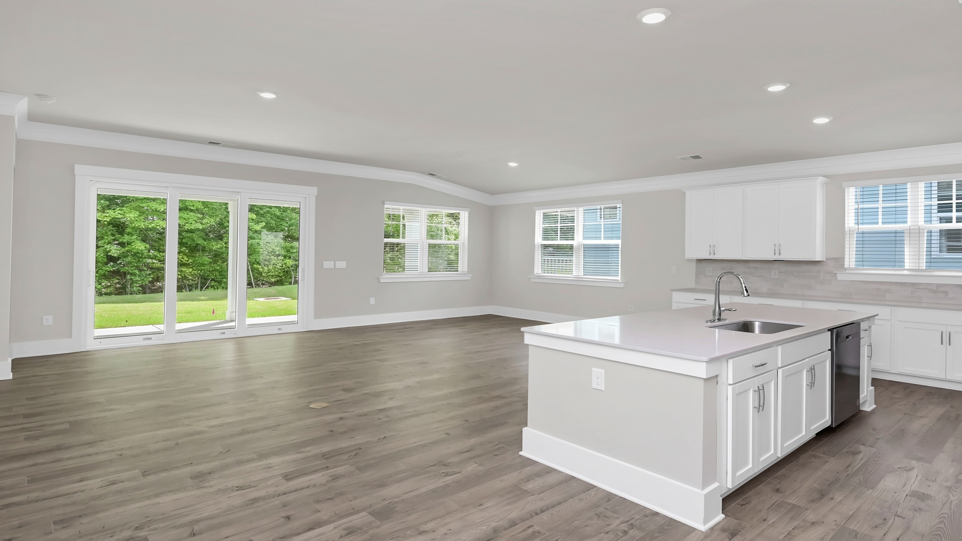 The kitchen island overlooks the open concept dining and living areas.