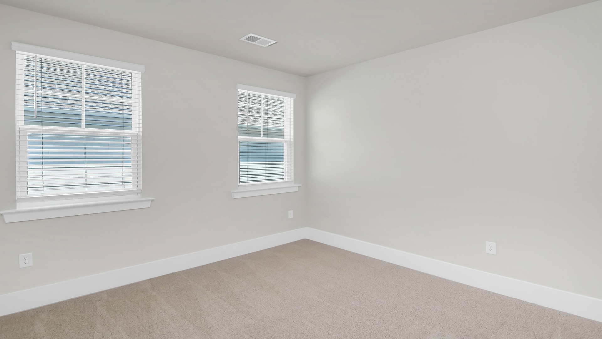 Bedroom 3 is central in the home and features carpet flooring and 2 windows,