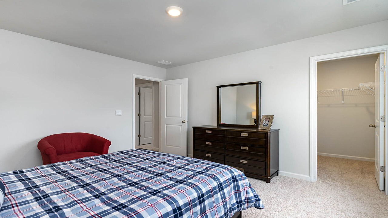 Bedroom 5 upstairs with carpet flooring and a walk-in closet