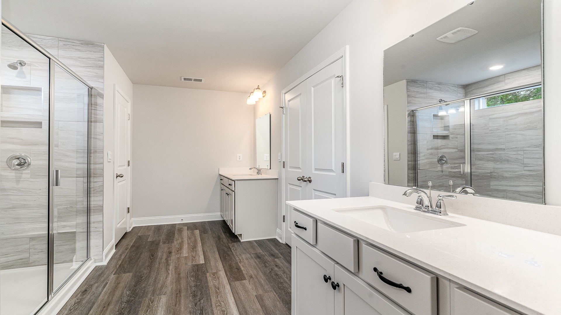 Primary bathroom with a standup shower and two vanities