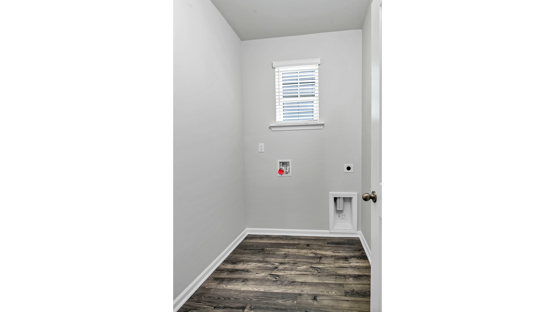 Laundry room at front of home with window for light and wire shelving