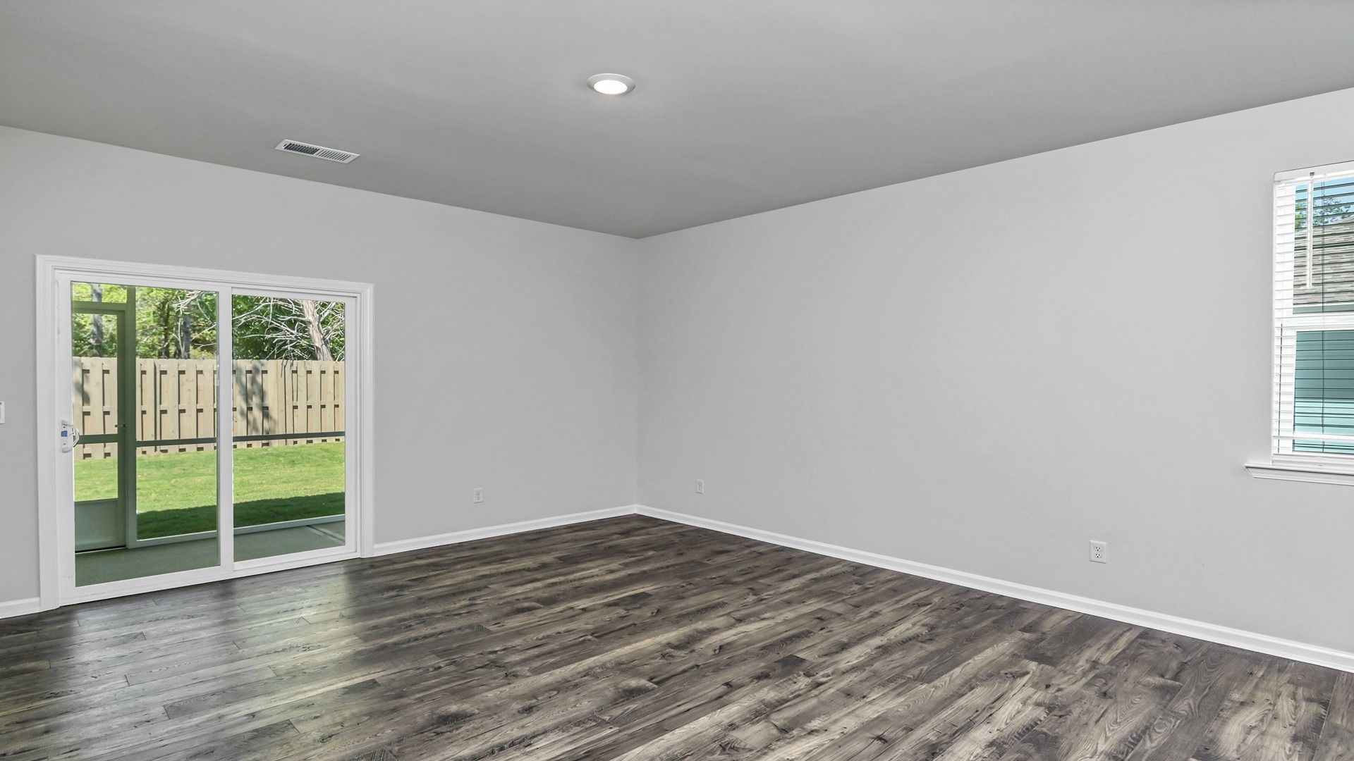 Back sliding doors in the living area lead out onto the paved back patio