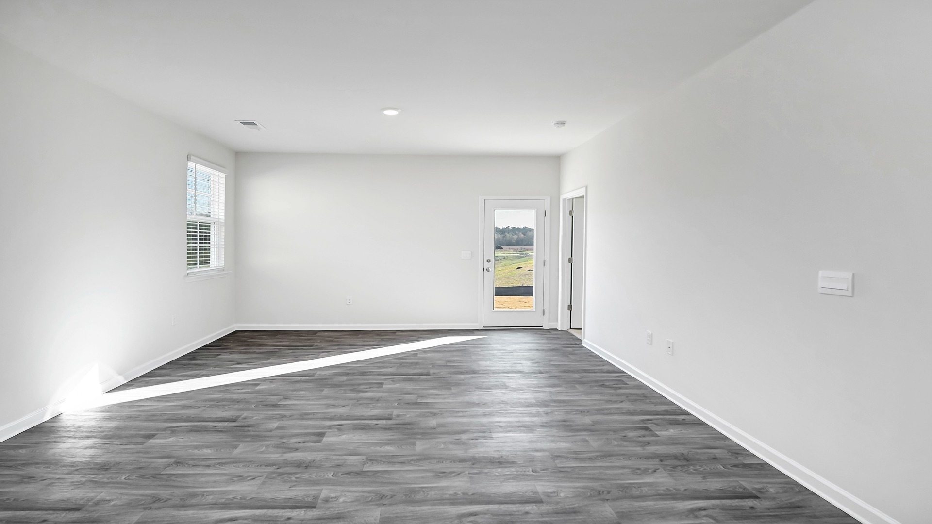 The living room is spacious with a window for natural light.