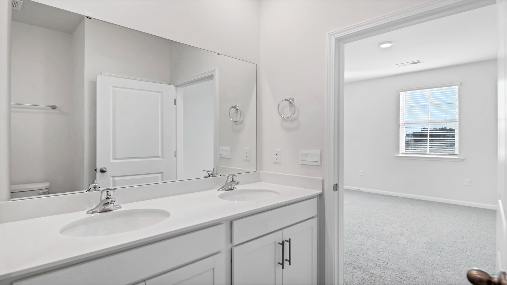 There are double sinks and cabinetry in the primary bathroom.