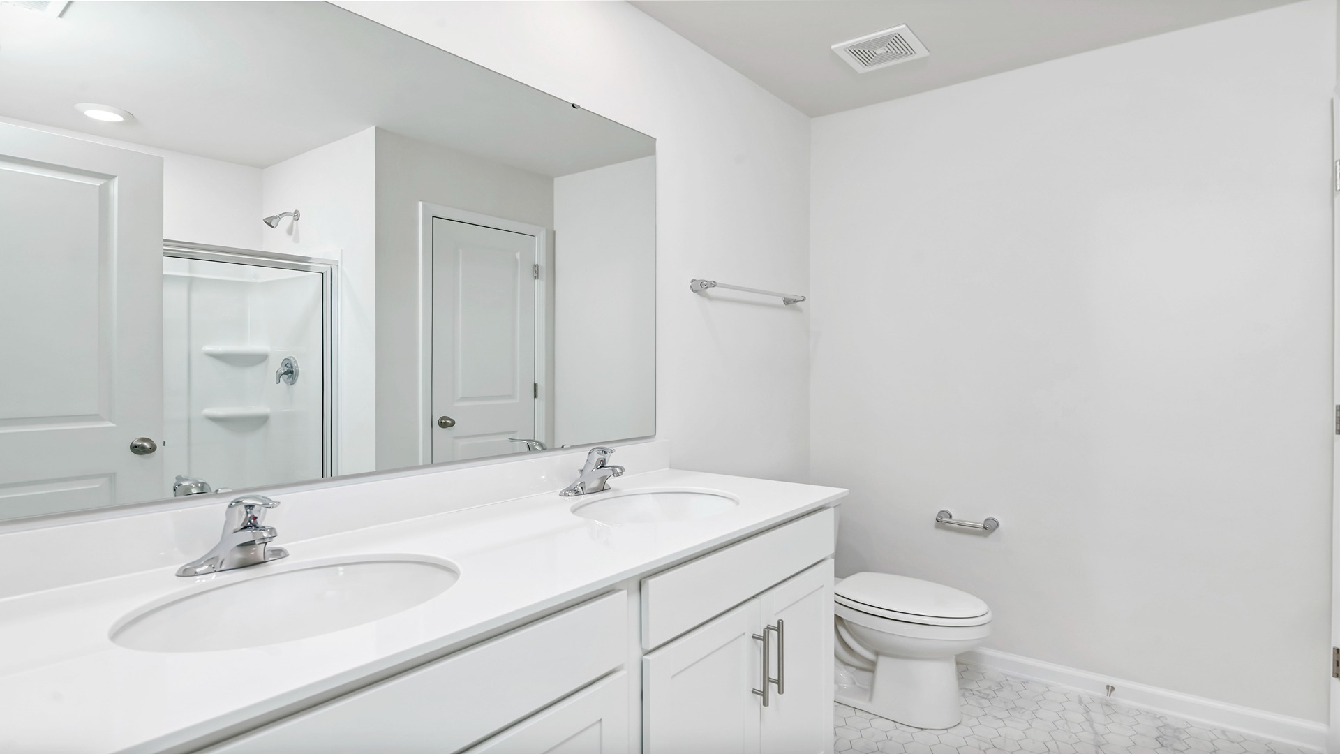 Primary bathroom with double vanity and white cabinetry