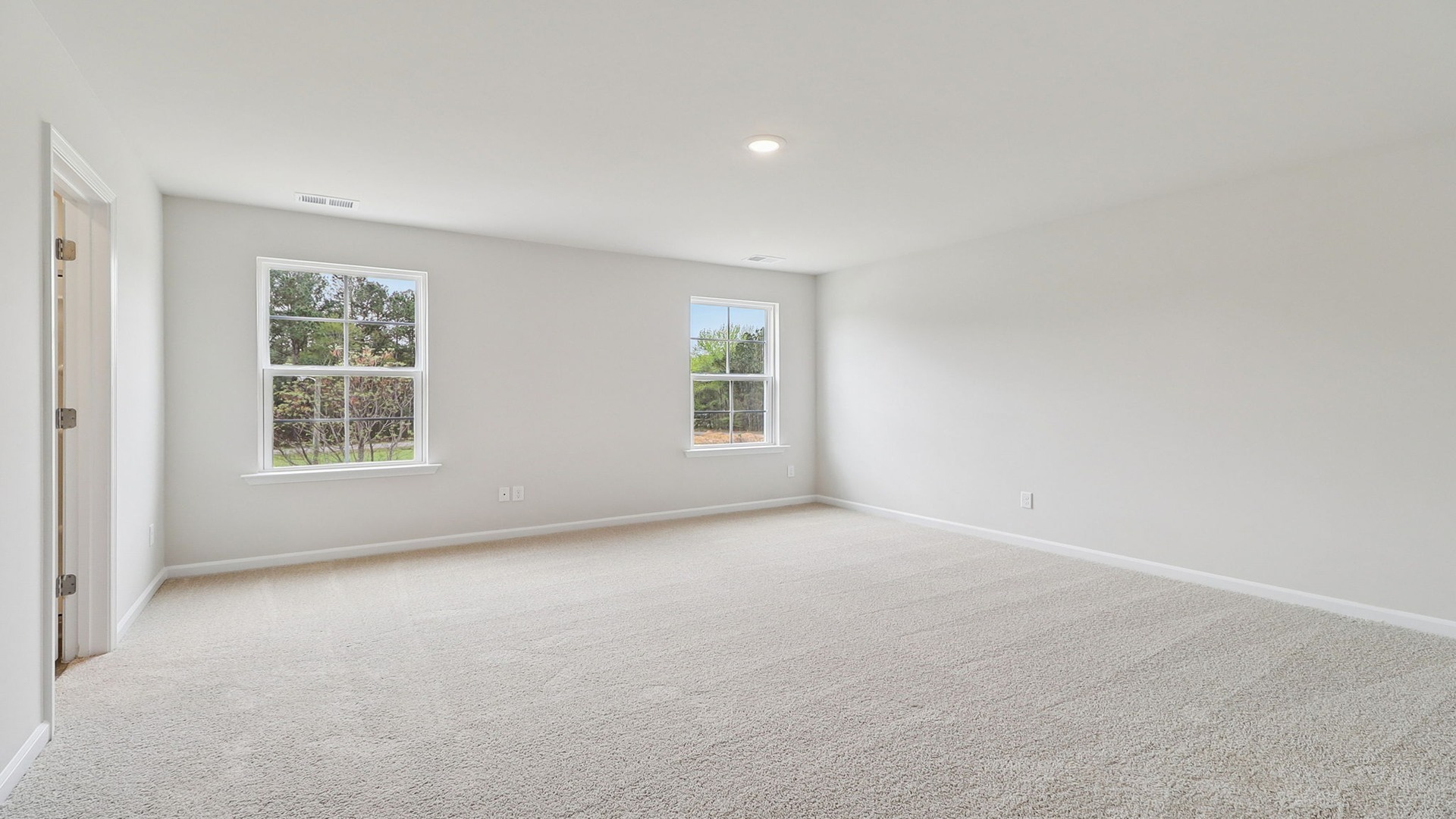 Primary bedroom upstairs with two windows for light and carpet flooring