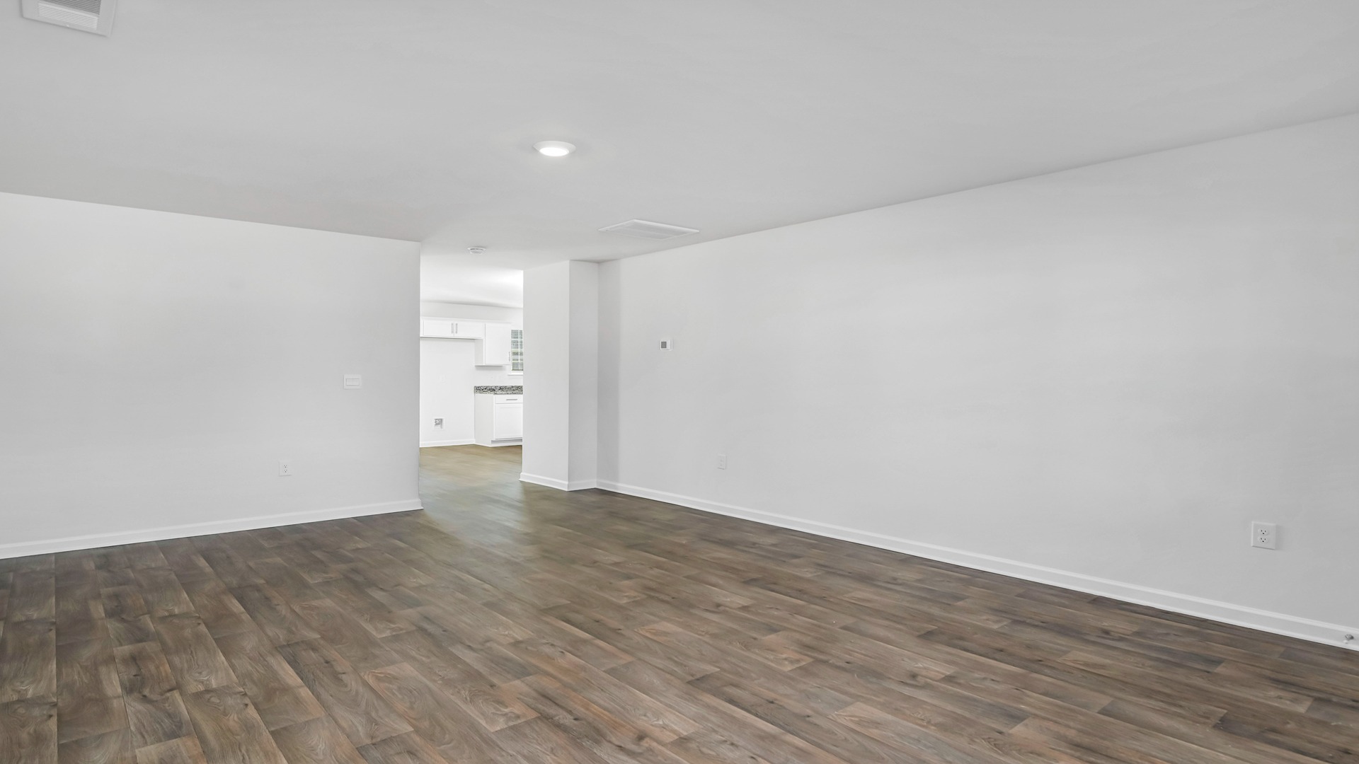 The living room is spacious with a window for natural light.