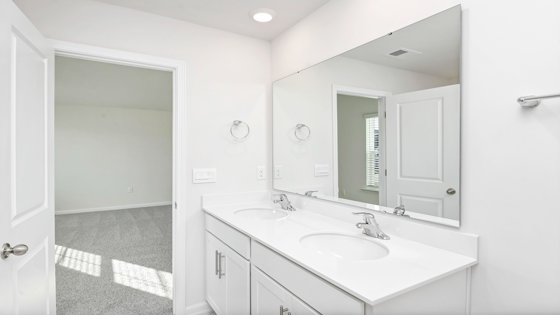 There are double sinks and cabinetry in the primary bathroom.