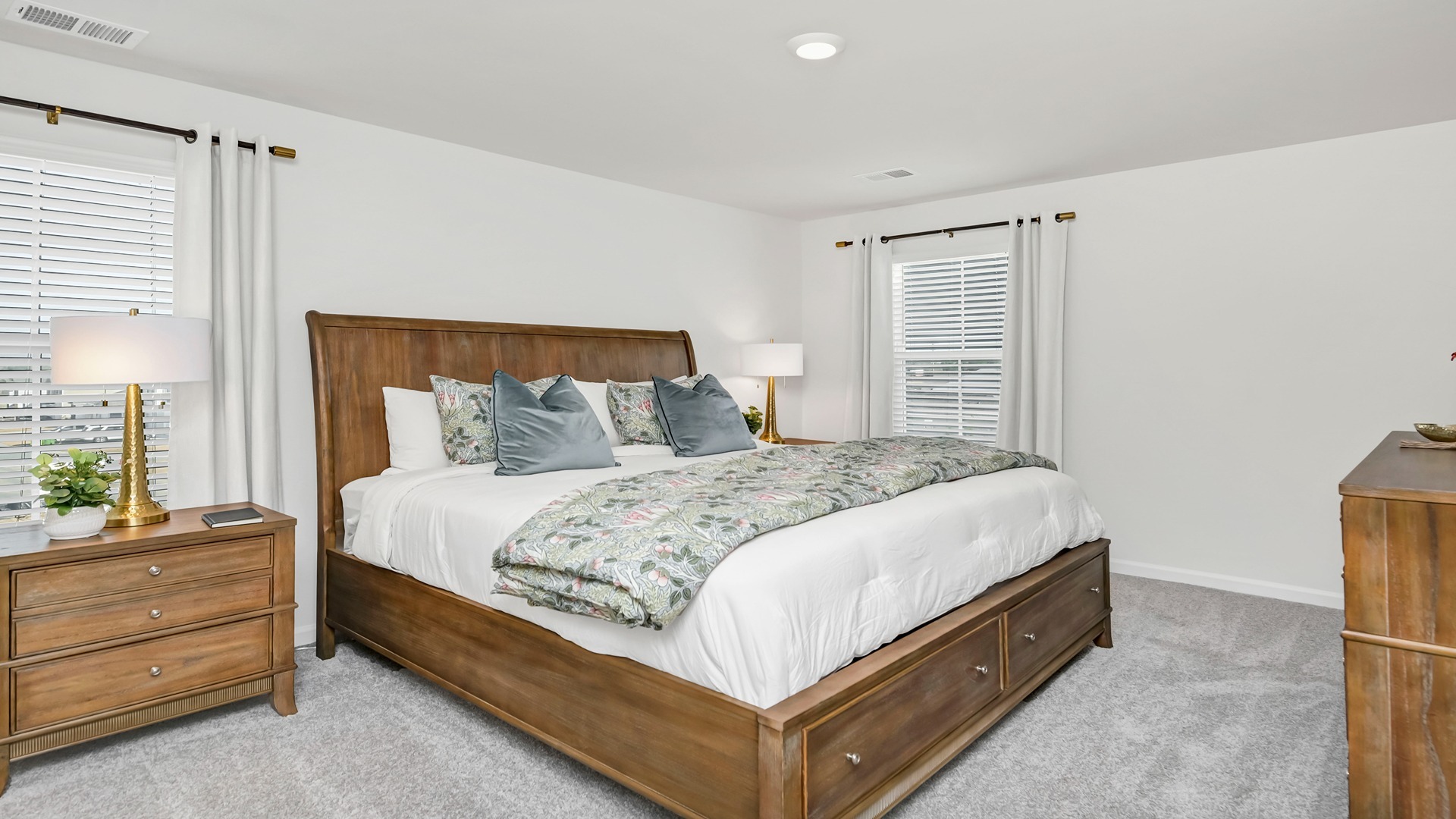 Primary bedroom upstairs with carpet floors and two windows for light