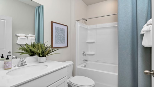 Bathroom 2 features a shower/tub combo and white cabinetry.