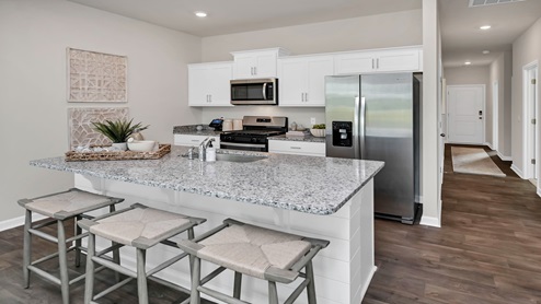The kitchen area features granite countertops and barstool seating.