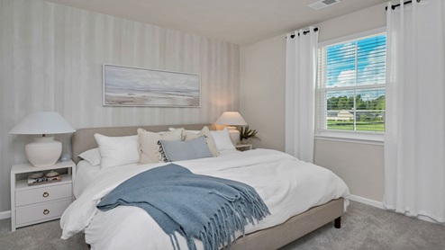 The primary bedroom is located towards the back of the home and comfortably fits a king bed.