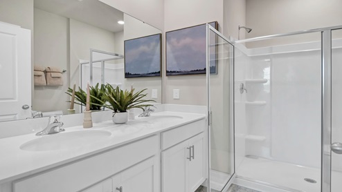 The primary bathroom features double sinks and a standup shower.