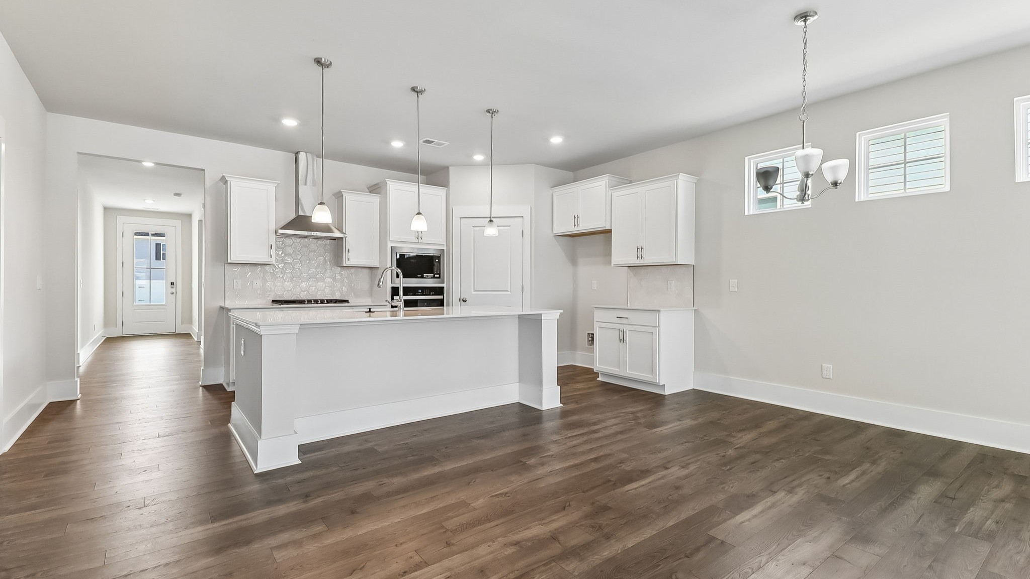 Kitchen space opens up at the end of the front foyer of new construction home in Shell Pointe