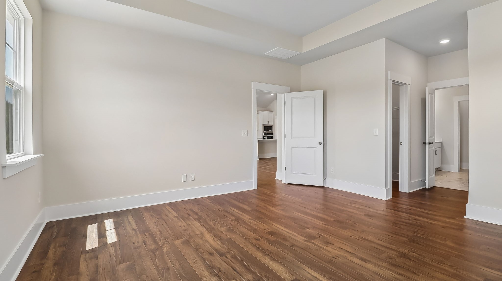 Tray ceilings and durable RevWood floors in private primary bedroom in the Litchfield floorplan in Shell Pointe