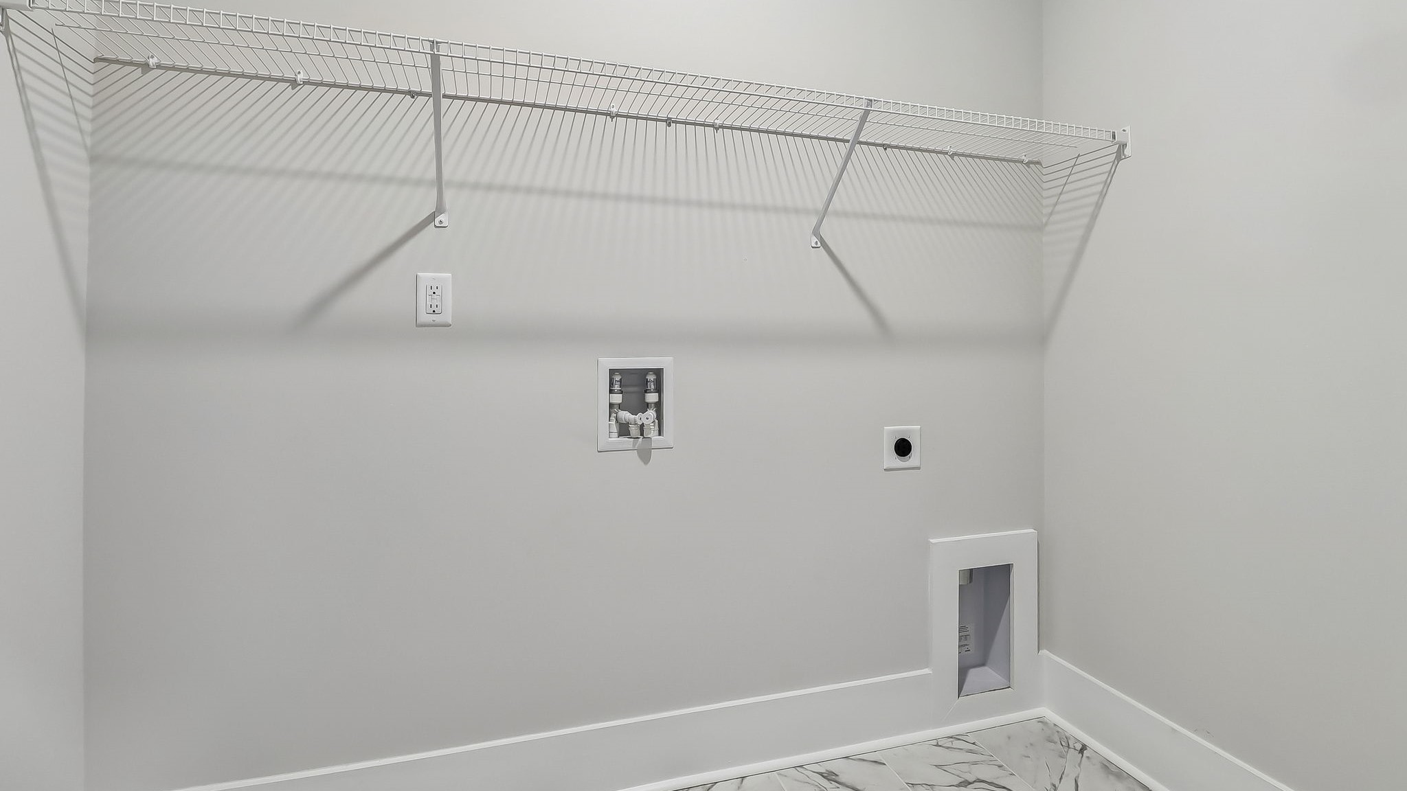Centrally located laundry room with tile flooring and wire shelving