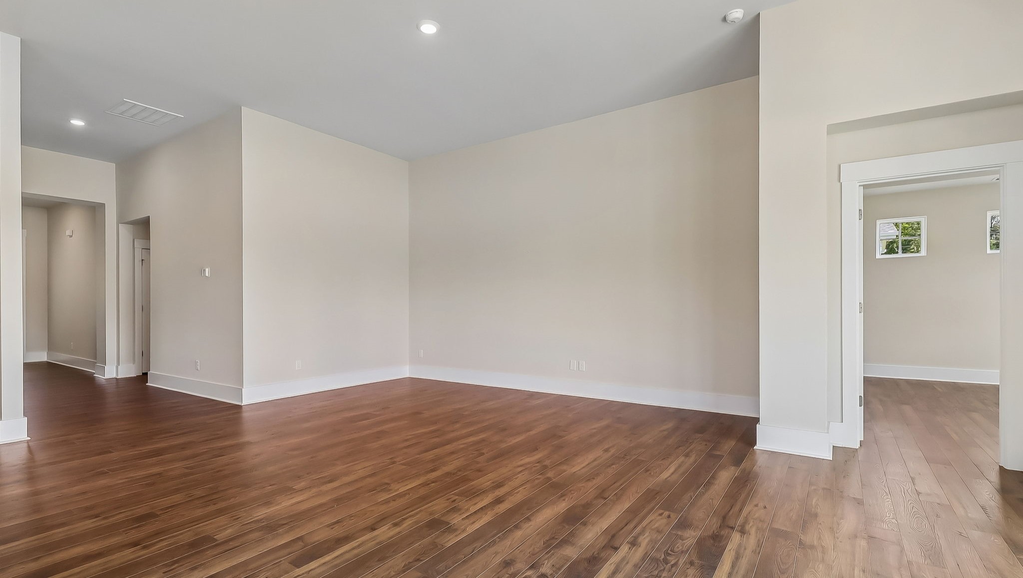 Access to primary suite off spacious living area with RevWood flooring