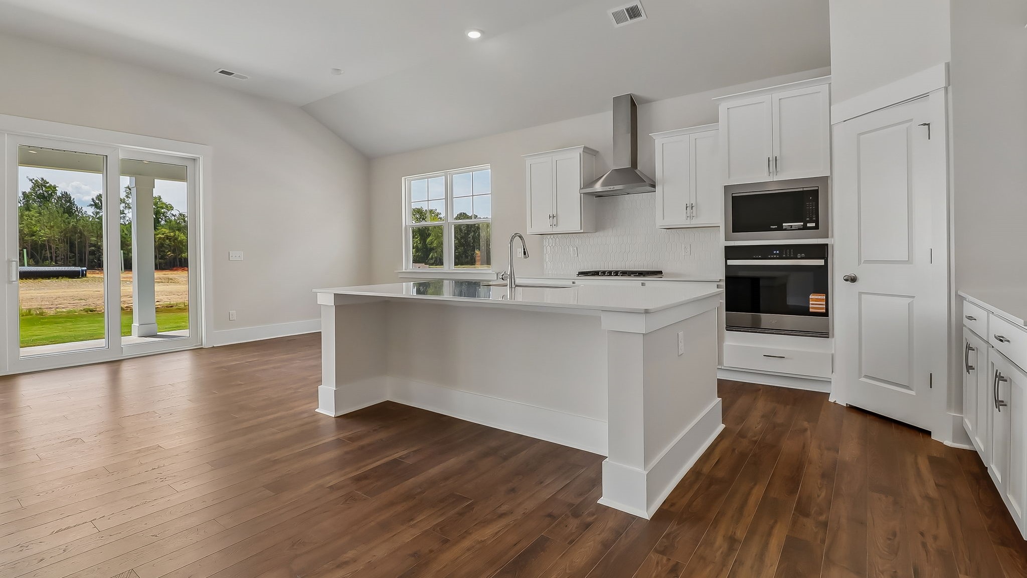 Sleek, white quartz countertops and tile backsplash in the kitchen