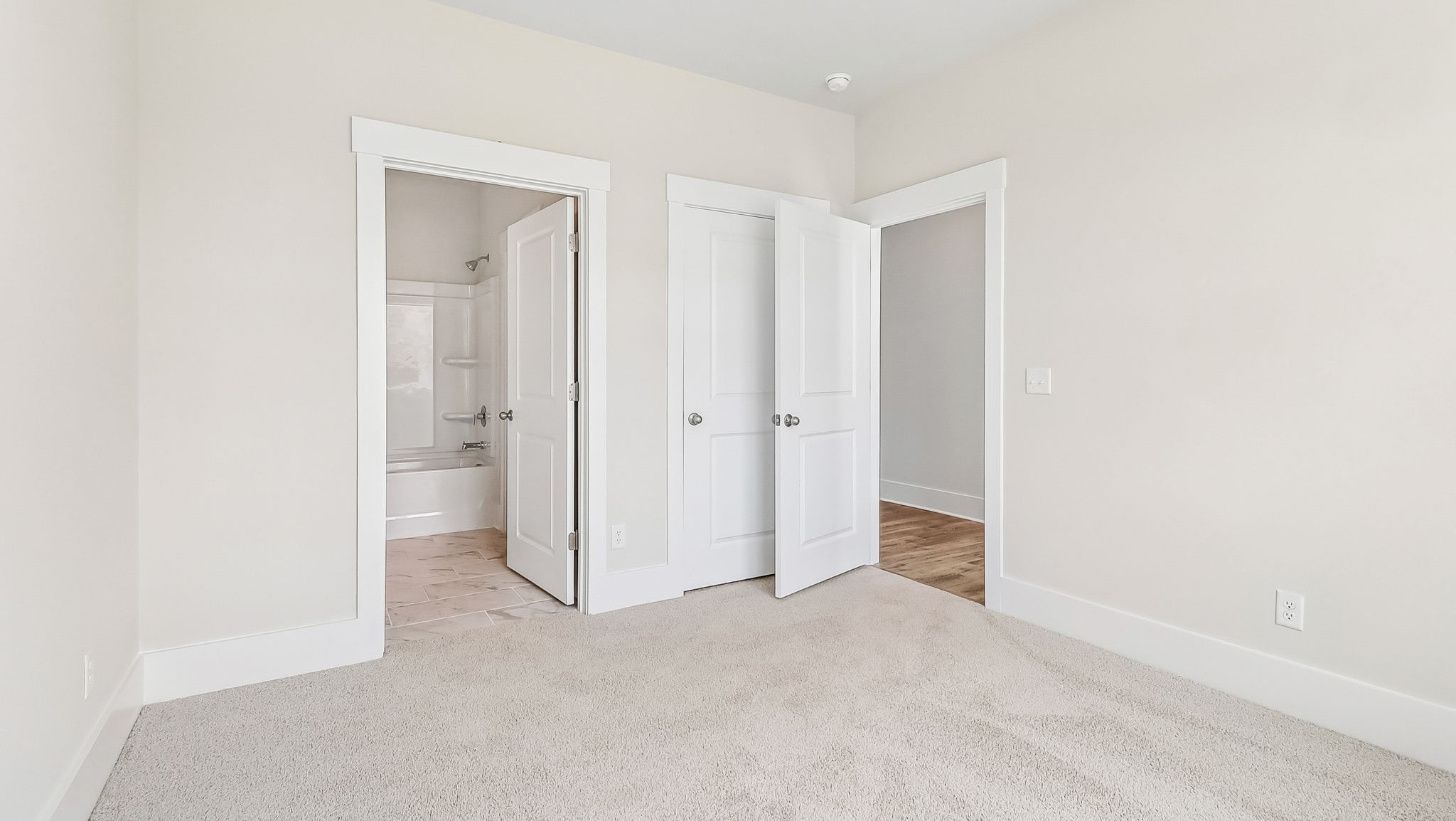 Front bedroom/bedroom 4 with carpet floors and direct access to bathroom 3
