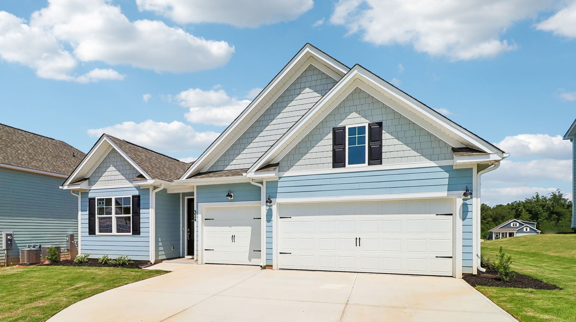 Blue Hardie Plank siding and black shutters on new construction home