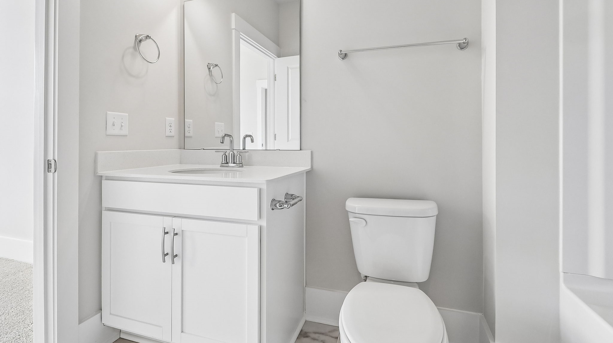 Bathroom 2 with single vanity with white cabinetry and quartz countertops