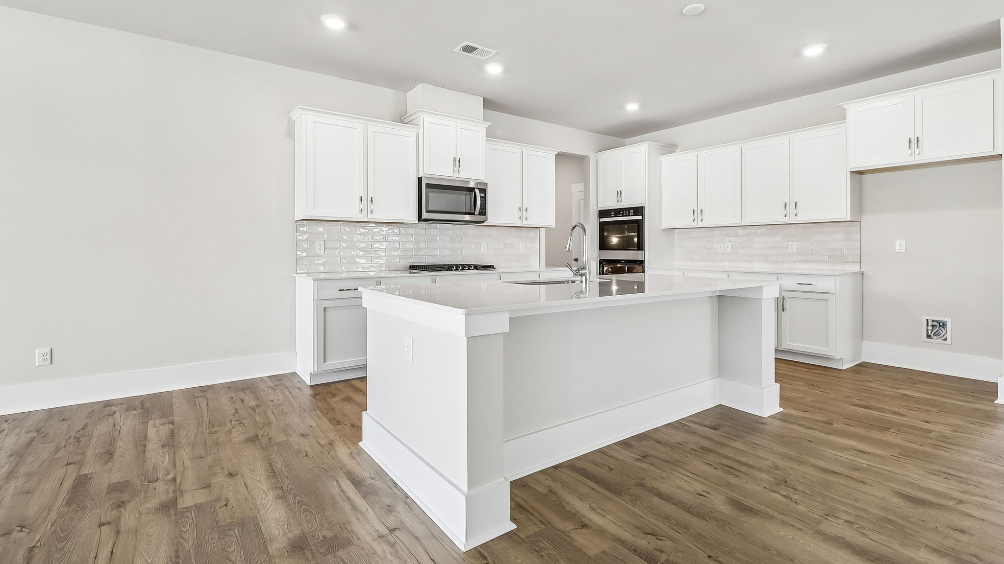 White cabinets in the open concept modern kitchen of new construction home on Lake Murray