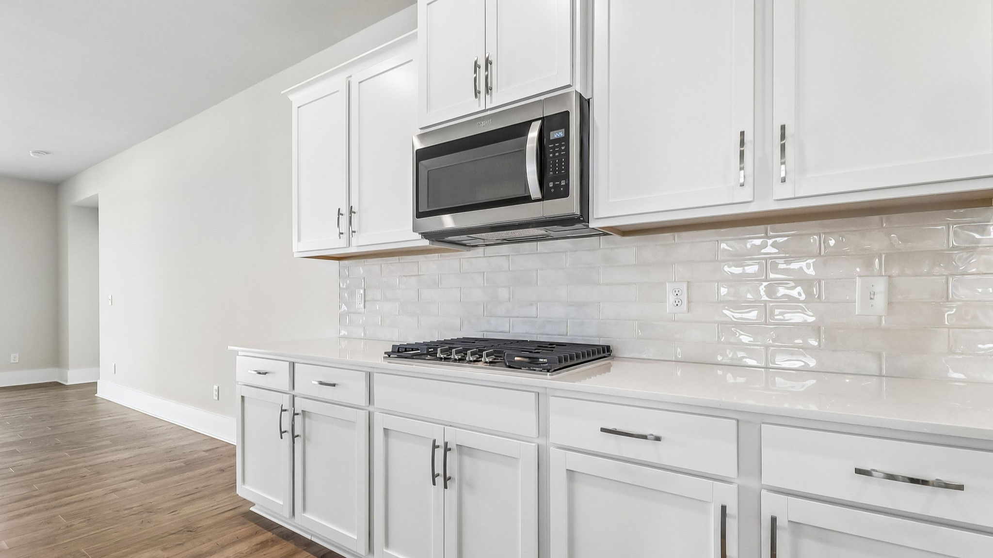 Tile backsplash and modern white quartz countertops in the kitchen of new home for sale in Shell Pointe