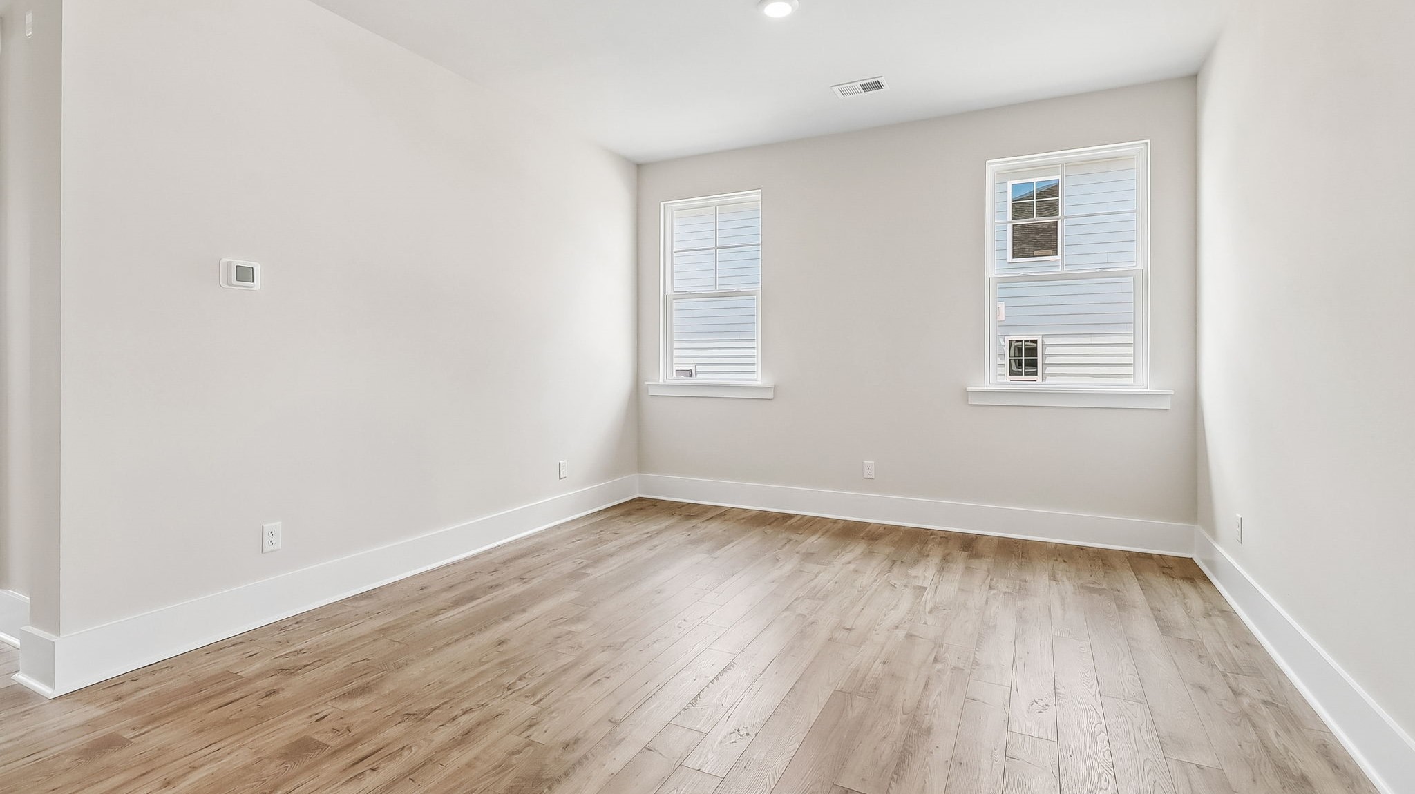 Designated dining area space with natural light from windows and RevWood flooring