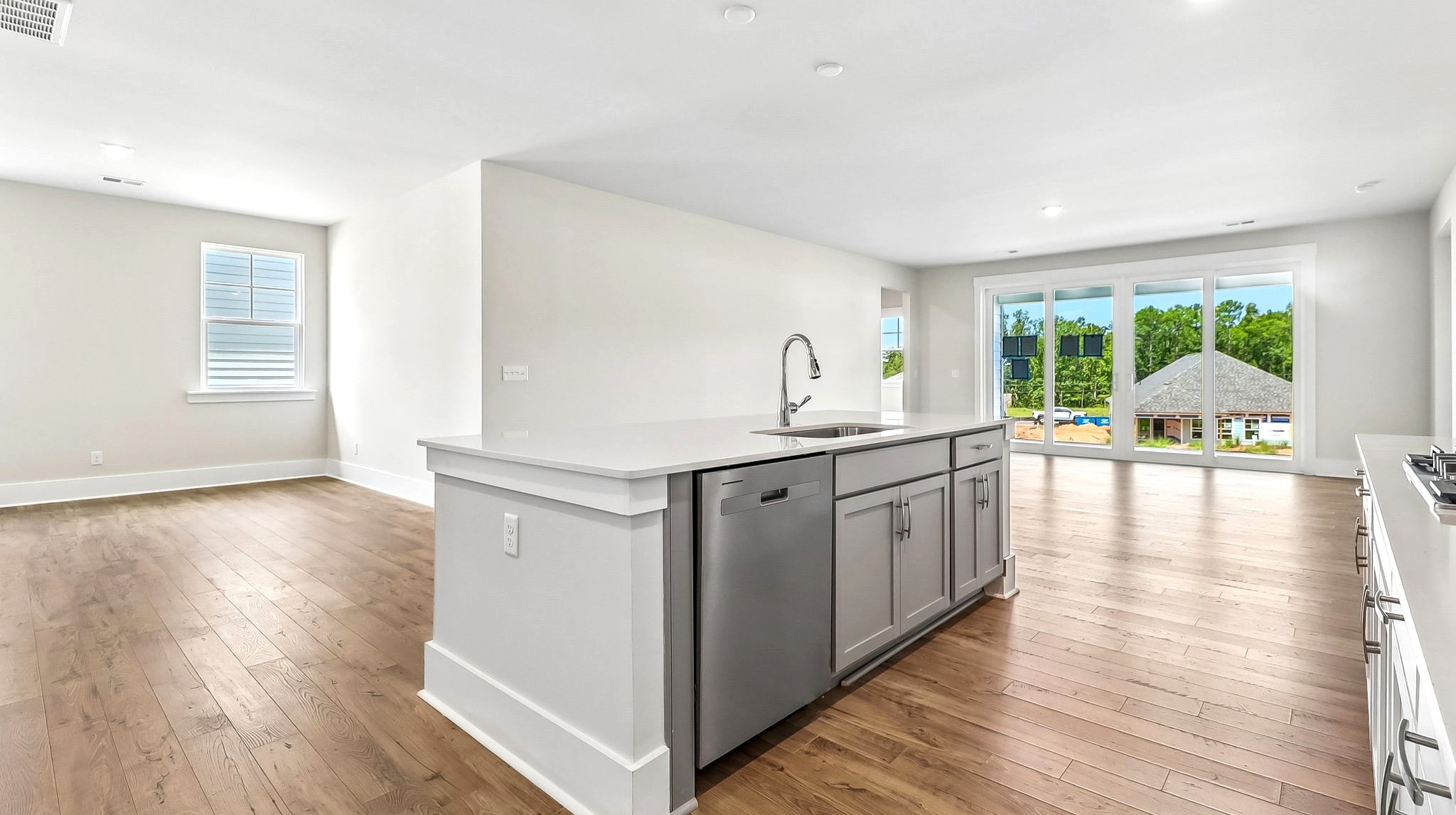 Floating island in new construction home overlooks the open concept dining and living areas with matching RevWood floors