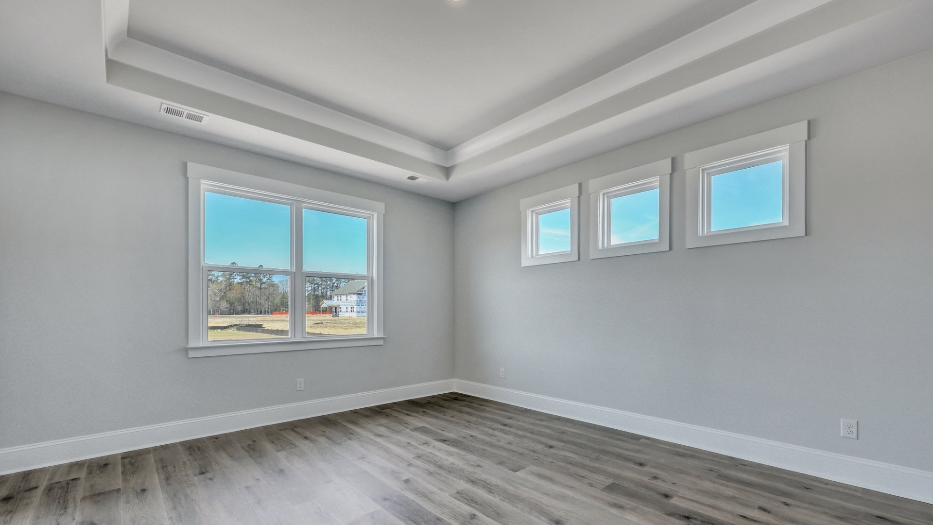 Primary bedroom privately tucked into the back of the new construction Trivecta floorplan in Shell Pointe