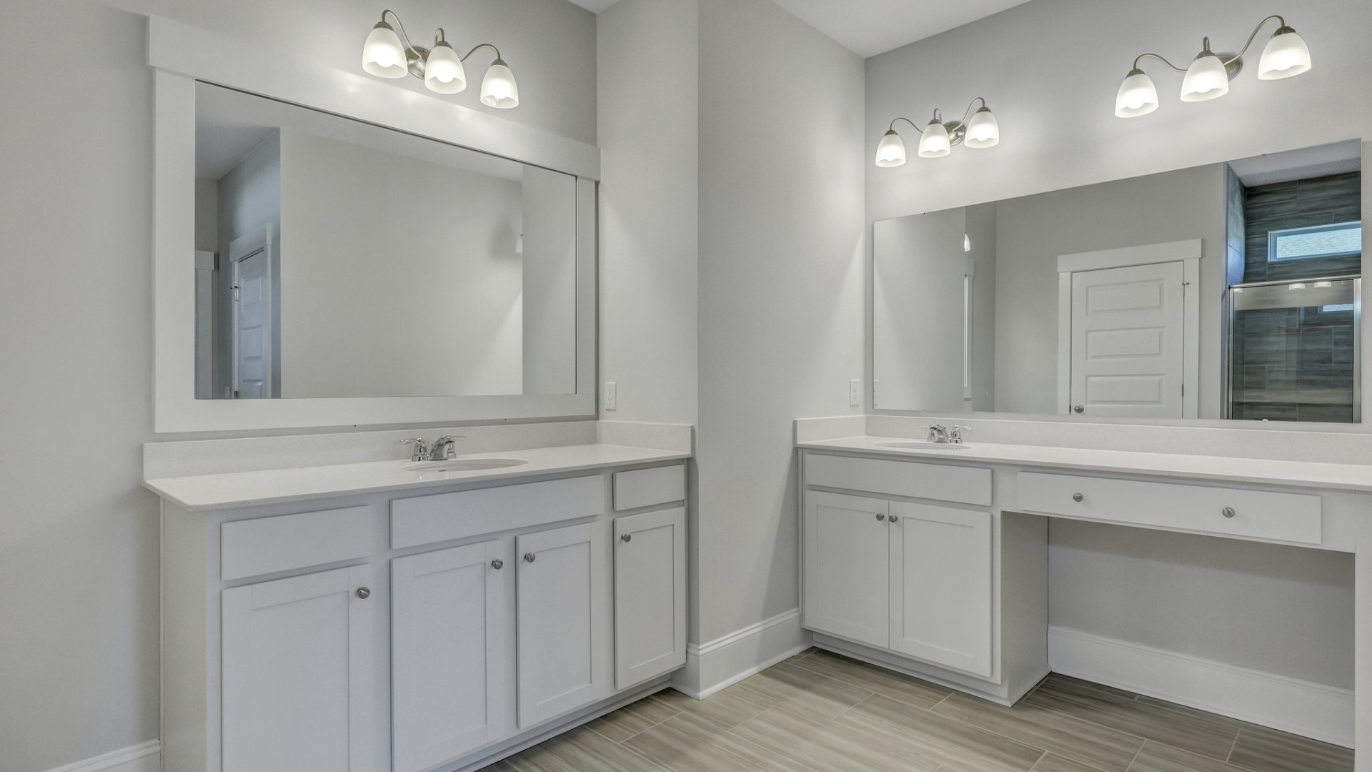 En-suite primary bathroom with two vanities and tile bathroom floors