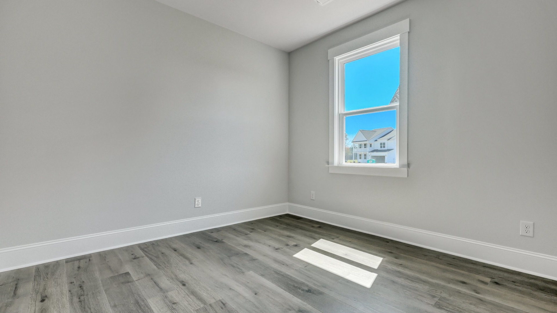 Bedroom 2 with window for light and neutral painted walls
