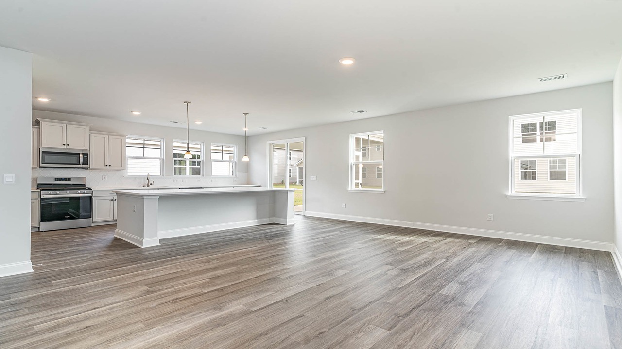 Completely open concept kitchen and dining areas with RevWood floors and windows for natural light