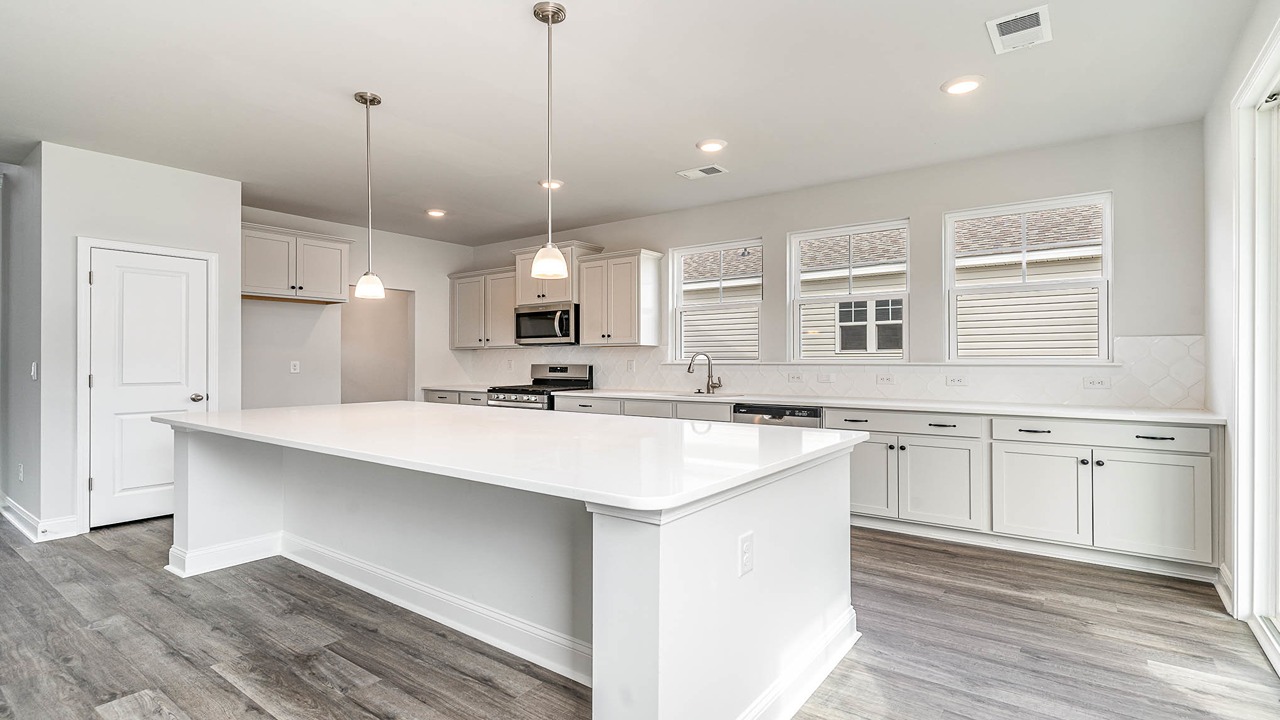 Modern kitchen in new home for sale in Shell Pointe with a floating island