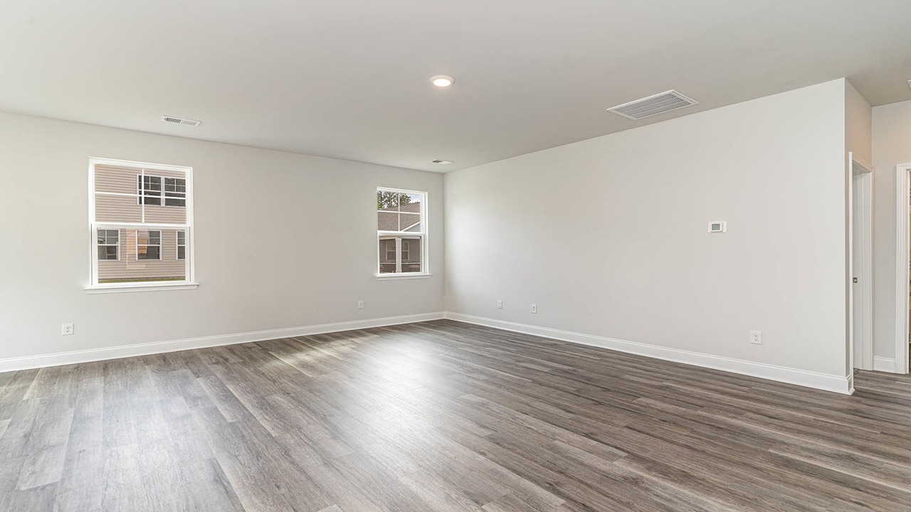 Spacious living area with windows facing the backyard and RevWood floors