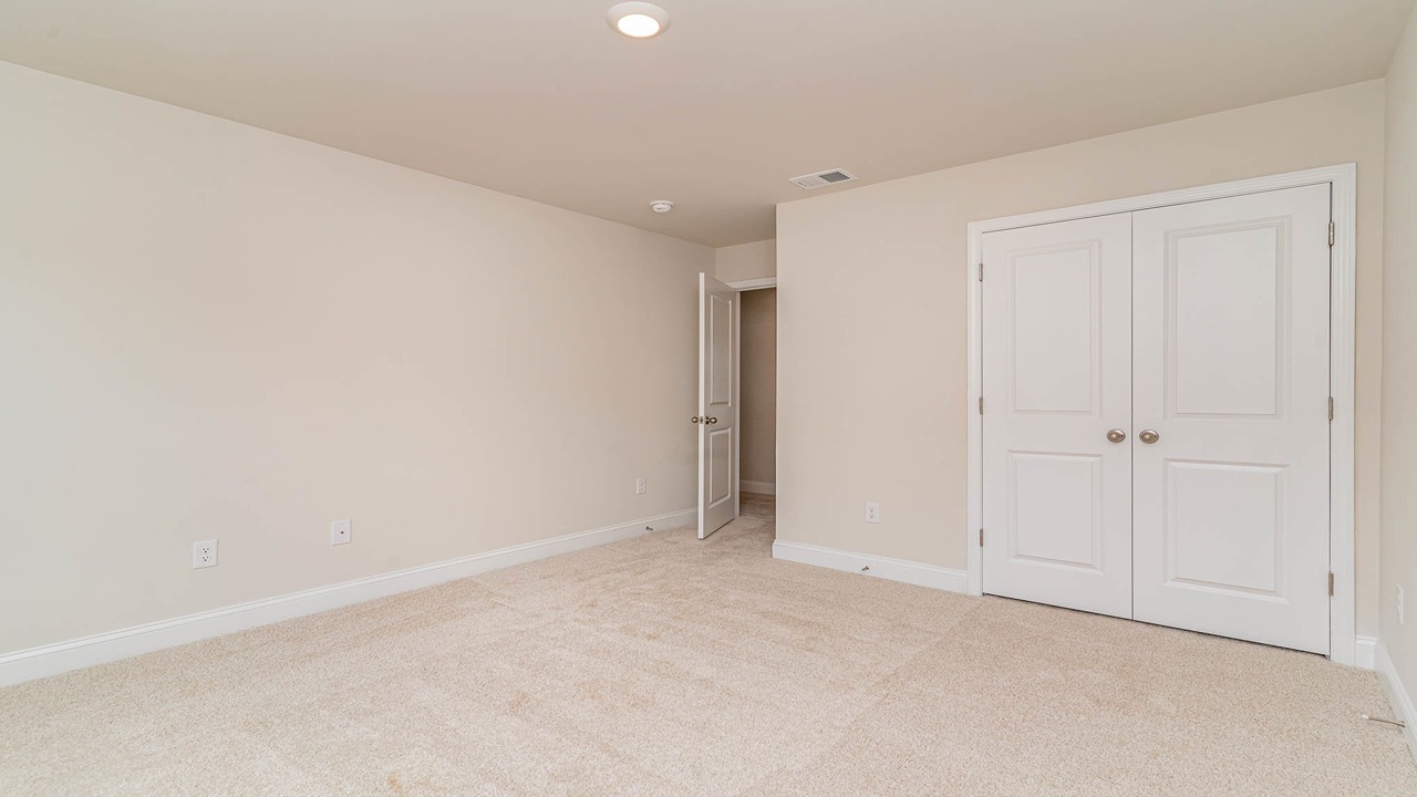Upstairs bedroom with several windows and French doors.