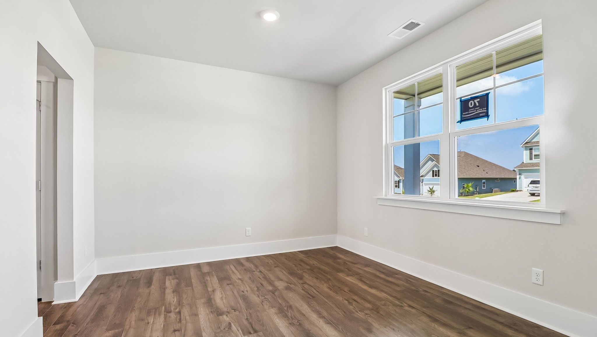 Dining area with Revwood flooring and a window at the front of the new home for sale