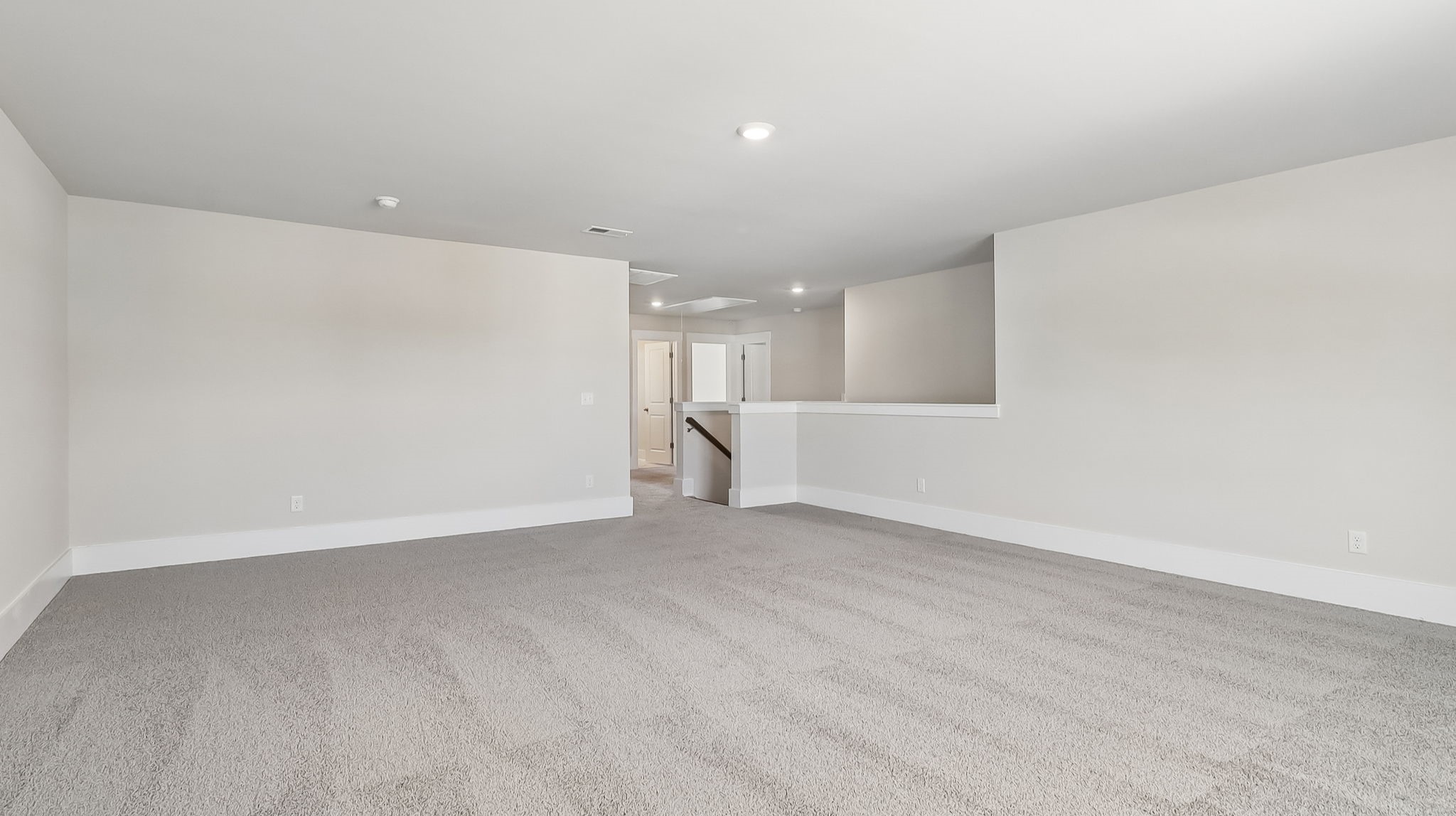 Large loft space upstairs with carpet flooring