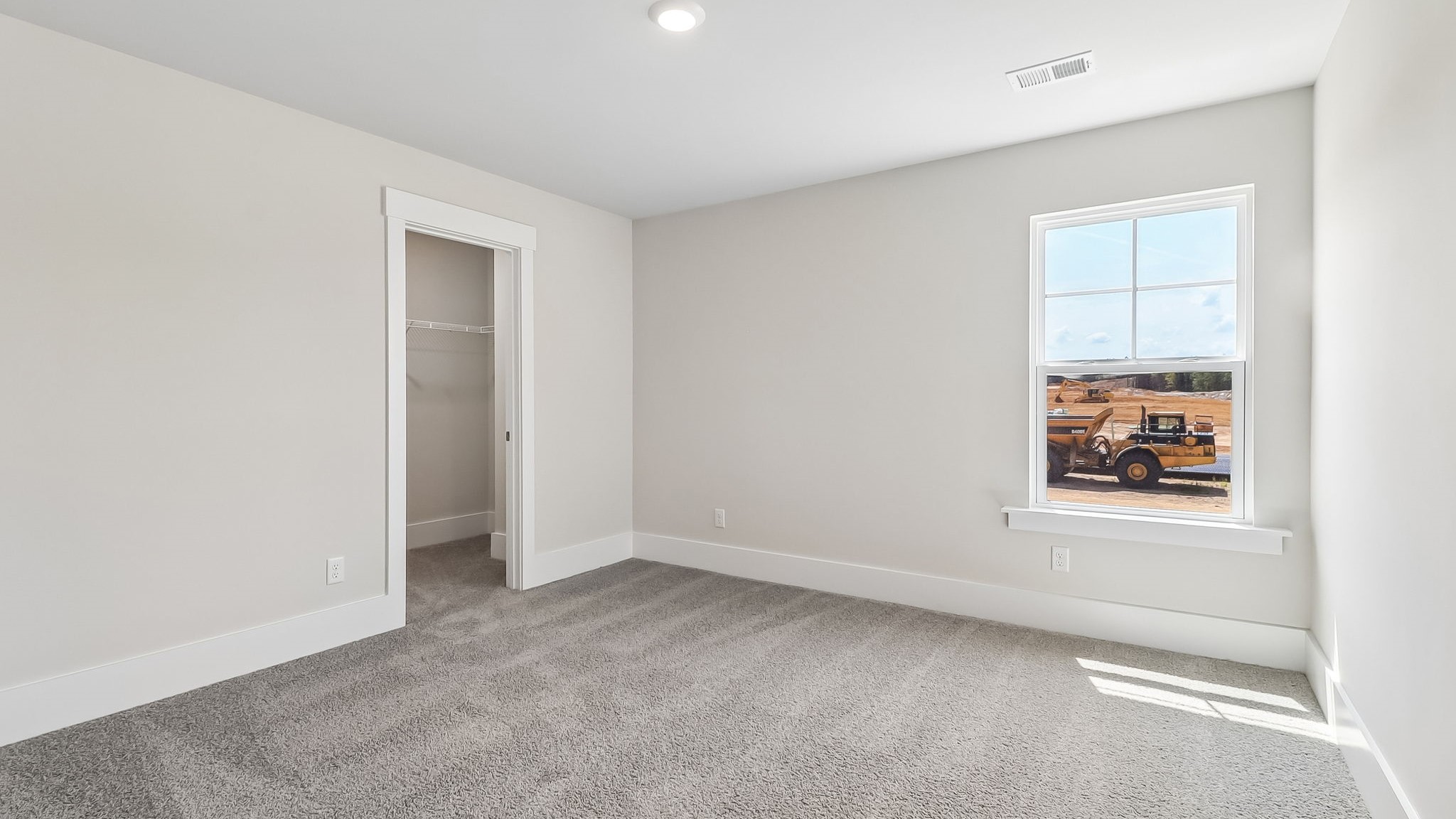Bedroom 4 with a walk-in closet and carpet flooring