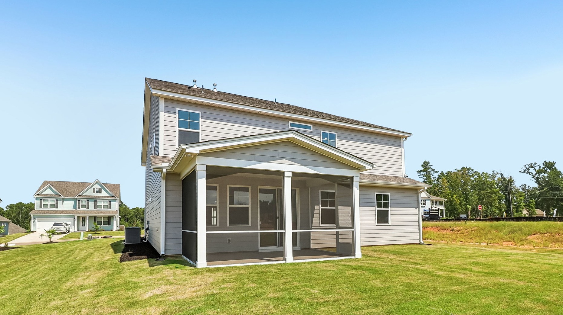 Back exterior of the home for sale with a covered, screened-in back patio