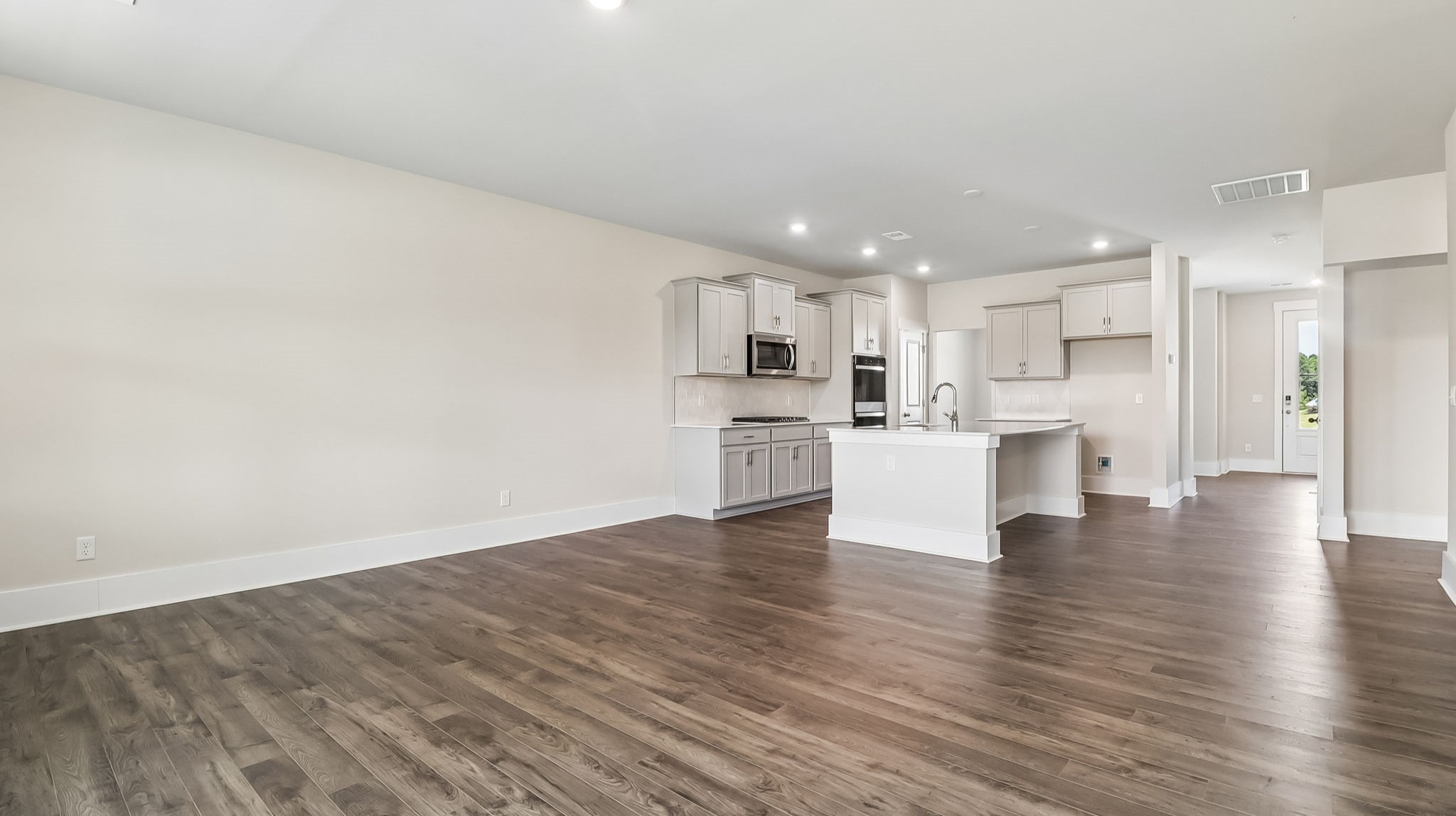 Open concept kitchen and living areas with matching RevWood floors
