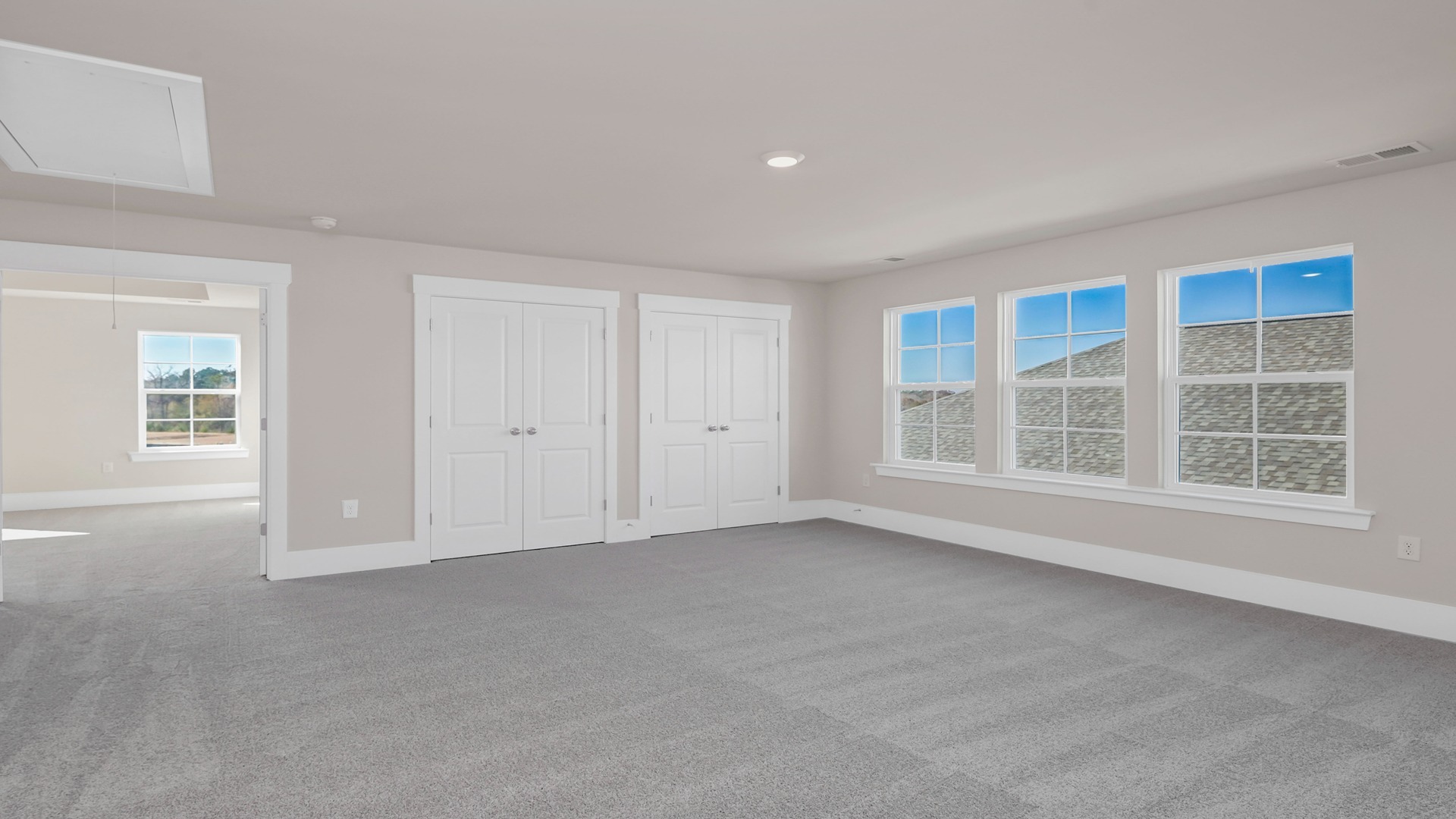 Upstairs loft space with carpet flooring and 3 large windows