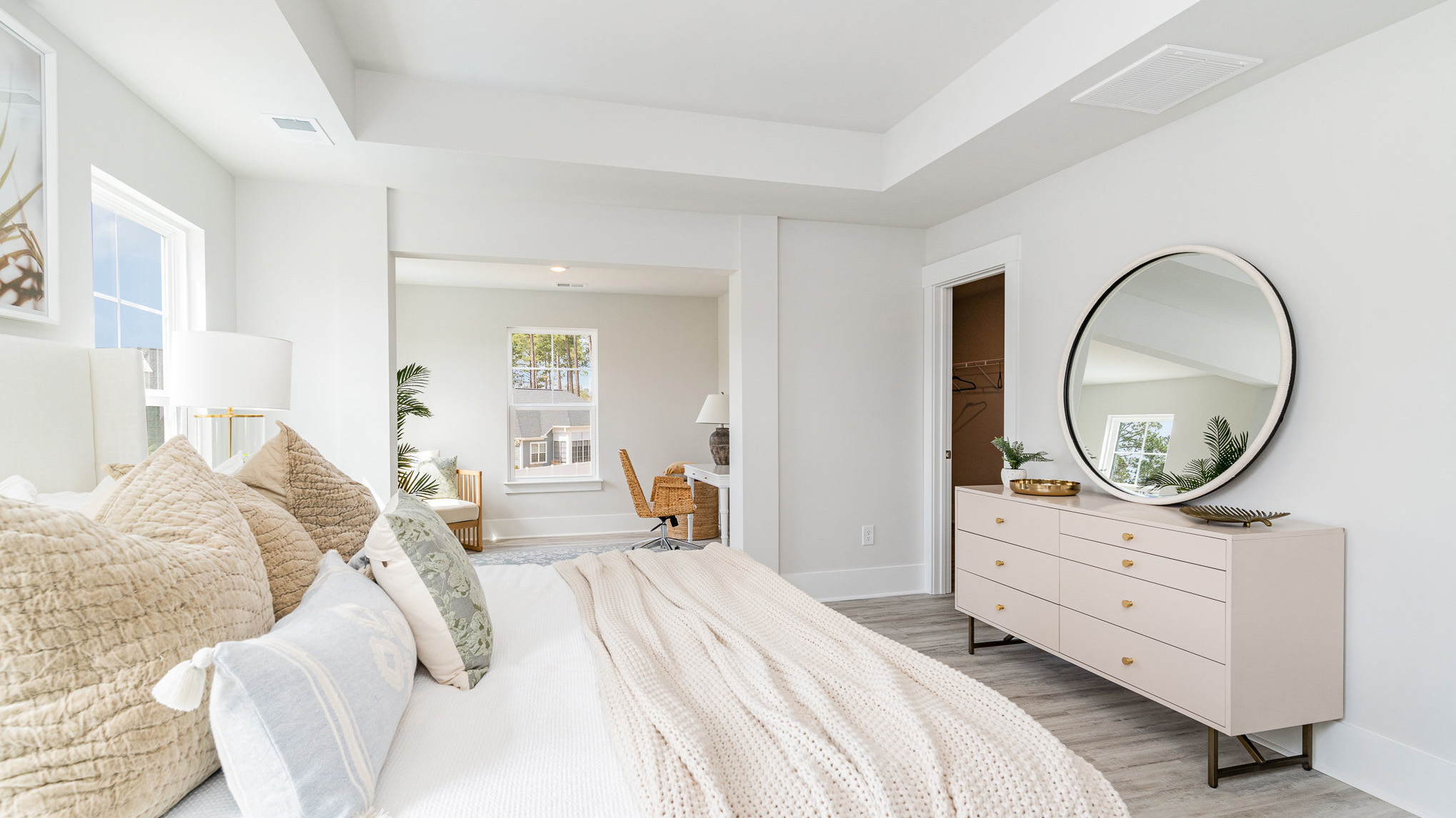 The primary bedroom is spacious with several windows and its own seating room