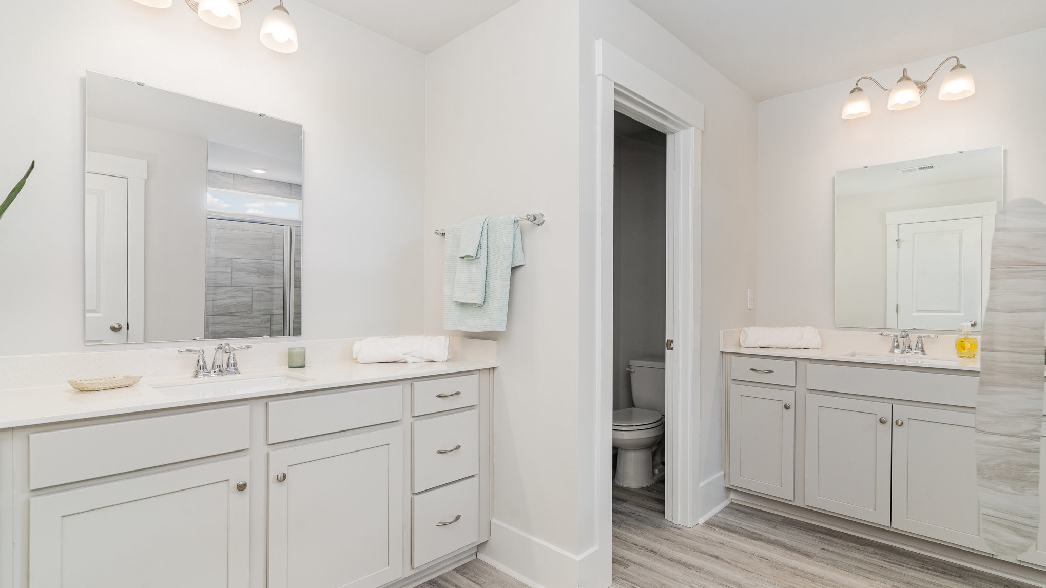 Primary bathroom with two vanities and a standup shower